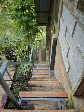 Looking down a rustic wood and metal outdoor staircase in a tropical garden Stock Photos