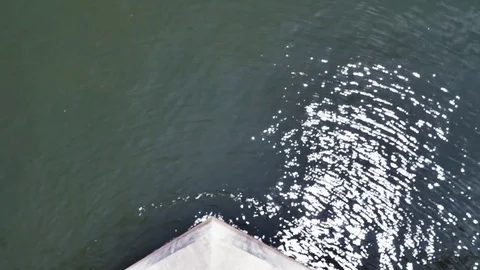 Looking down at shimmering water on top of a high bridge 스톡 동영상 76991739