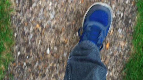 Looking down shot of someone walking along a straight concrete path. Stock Footage 280347852