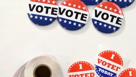 Looking down slider on VOTE buttons and I VOTED TODAY stickers on table Stock Footage 125202671