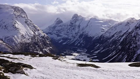 Looking down on a snowy valley surrounded by huge mountains in Norway Stock Footage 267721300