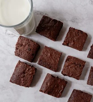 Looking down at squared brownies and a glass of milk on top of a granite kitchen 写真素材