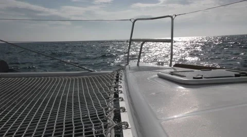 Looking down the starboard hull of catamaran as waves crash into bow a nd spr Stock Footage 67863390