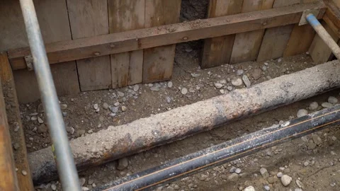 Looking down on steel and electrical pipe on street construction site Stock Footage 263629899