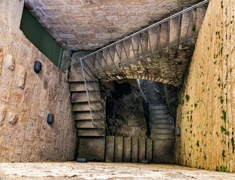 Looking down a stone spiral staircase inside a historic medieval tower Фото