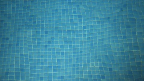 Looking down into a swimming pool at night at the refracted pool tiles on Video stock 113183719