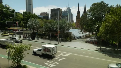 Looking down at Sydney traffic and St Mary's Cathedral from a window 6K Vídeos de archivo 300148167