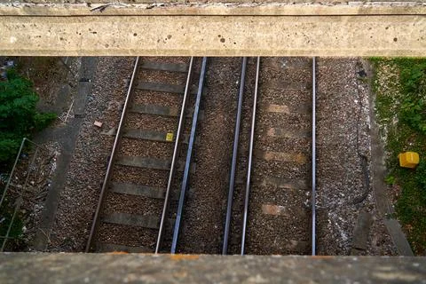 Looking down through a bridge on a pair of train lines below Stock Photos