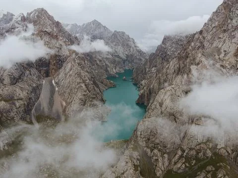 Looking down through the clouds at the hidden Kel-Suu lake Stock Photos