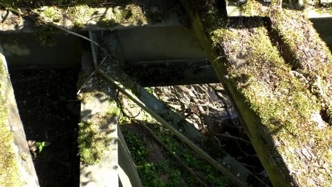 Looking down through the damaged floor of an abandoned railway bridge Stock Footage 76767650