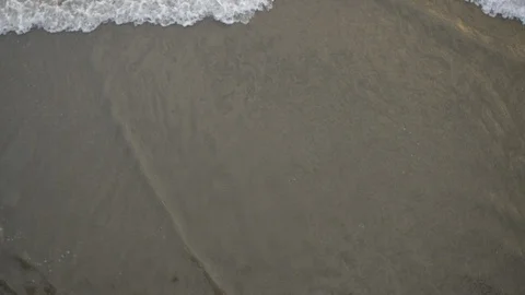 Looking down at the tide Coming in at the beach Stock Footage 95566959