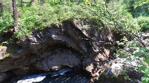 Looking down from the top of the hill on the waterfall trough the green trees in Video stock 128409610