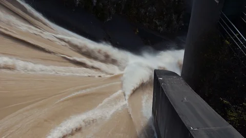 Looking down top view hydro power dam brown flood downstream Stock Footage 120033609