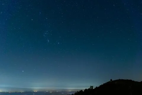 Looking down on a town at night, covered in fog. With the night sky Stock Photos