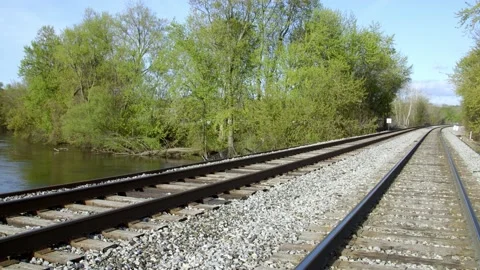 Looking down train tracks by a river. 4k60p Video stock 130815044