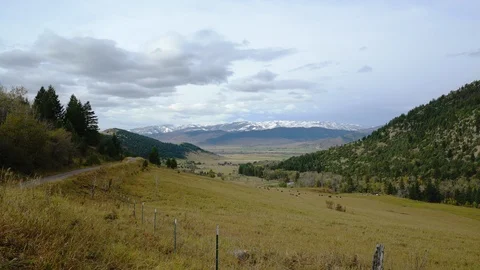 Looking down a valley on a fall day in Montana with snowy mountains Video stock 121063634
