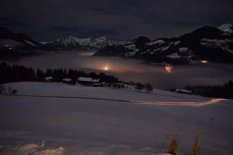 Looking Down into the valley filled with Clouds Lit up by New Year Fireworks Stock Photos