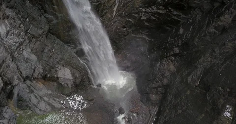 Looking down into a waterfall's box canyon while snow falls around the camera Video stock 111308946