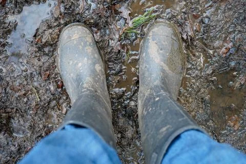 Looking down at welly boots standing in a muddy puddle 스톡 사진