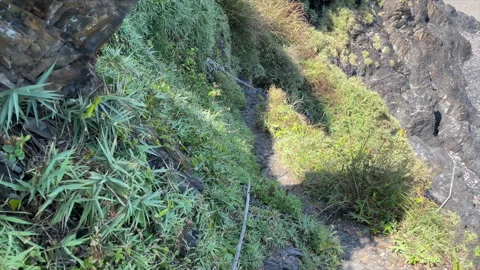 Looking Down While Walking A Rocky Coastal Path Beside A Rusted Chain Rail Stock Footage 342838462