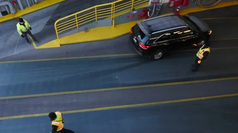 Looking down at workers directing traffic onto a car ferry Video stock 141018630