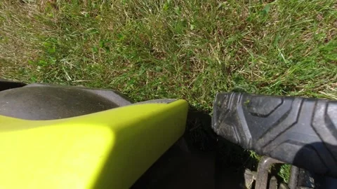 Looking downward on a lawn mower while it mows grass 스톡 동영상 312767477