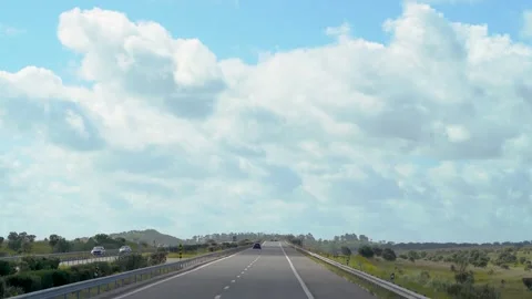 Looking up from drive on highway with beauiful clouds on horizon Stock Footage 273674299