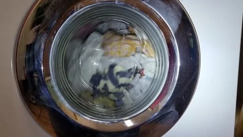 Looking into the drum of a running washing machine with colorful clothes. Stock Footage 322075803
