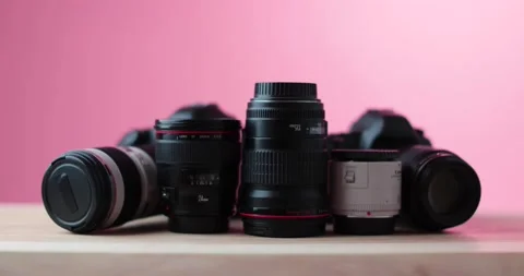 Looking at expensive high Quality Camera lenses with a red studio background Stock Footage 237546538