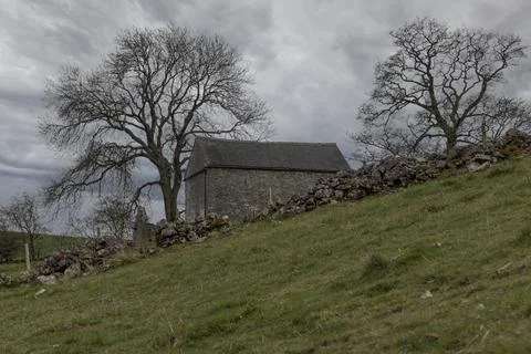 Looking a field at a stone building Stock Photos