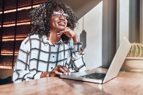 Looking forward to the future! Young beautiful african american woman works o Foto stock