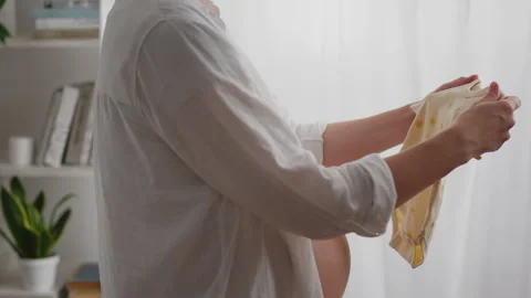 Looking forward to her baby, the expectant mother carefully collects a colle Stock Footage 263903158
