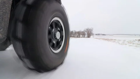 Looking forward as a side-by-side ATV drives down a country road in the snow. Stock Footage 119973410