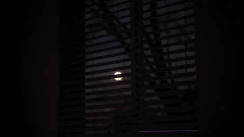 Looking at full moon through window with blinds. Close up shot Vidéo 304019944