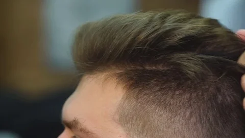 Looking good already. Close up side view of young bearded man getting groomed by Stock Footage 70951462