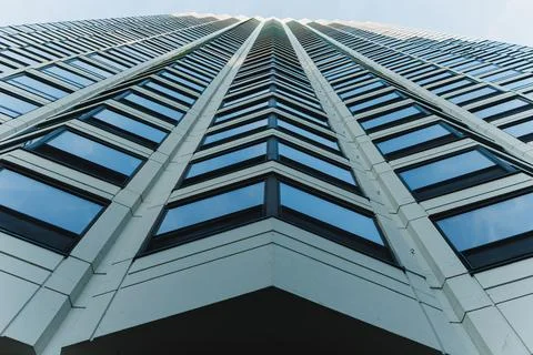 Looking up at a high-rise building from the base shows the repeating windows  写真素材
