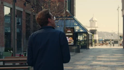 Looking on his phone while walking down a financial alley modern lifestyle Stock Footage 135264956