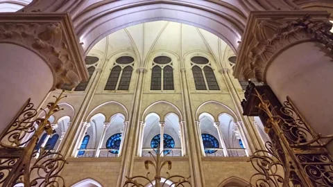 Looking up at the illuminated arched ceilings inside the Notre Dame cathedral Stock Footage 302573797