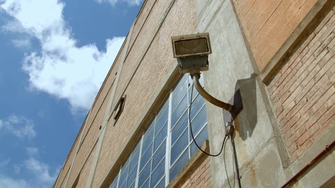 Looking up at an industrial light on the brick building wall. 4k60p Stock Footage 130143001