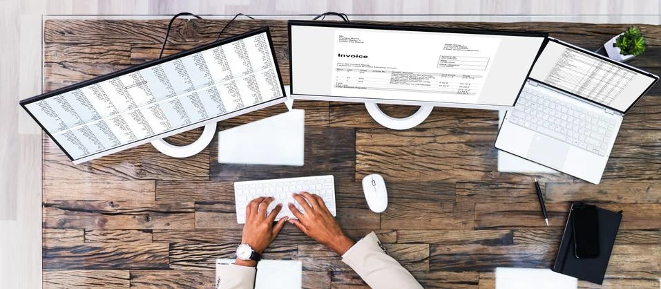 Looking At Invoice And Spreadsheet On Computer Stock Photos