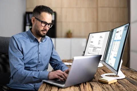 Looking At Invoice And Spreadsheet On Computer Stock Photos