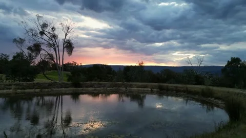 Looking at lake reflection of sunset on a dark and moody evening Stock Footage 312098290