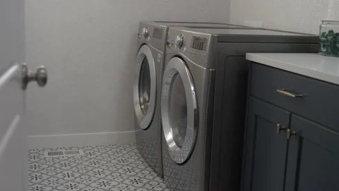 Looking into the laundry room of a home with front loading washer and dryer Stock Footage 147415694