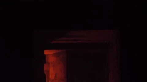 Looking on the man in hood making fire in the giant abandoned hall Stock Footage 144670288