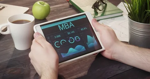 Looking at MBA records using digital tablet at desk Stock Footage