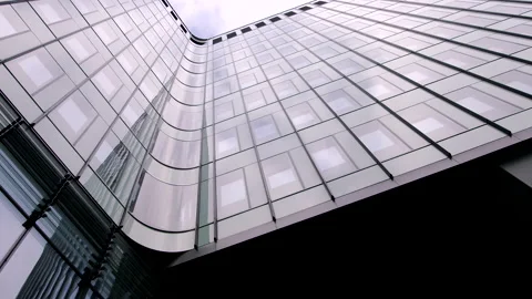 Looking up at modern office building with reflections on glass wall Stock Footage 150956413