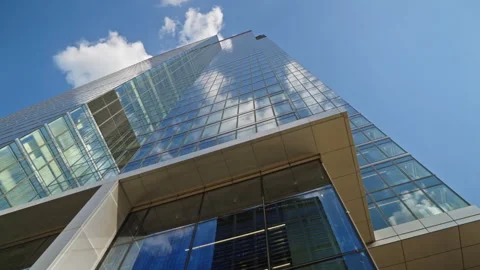 Looking up modern office tower building blue sky reflections in skyscraper glass Stock Footage 335728610