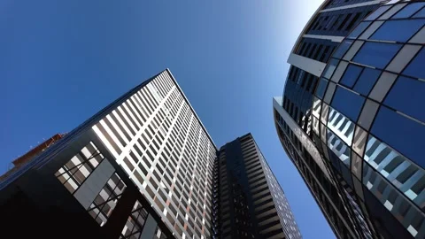 Looking up at modern skyscrapers and blue sky Stock Footage 334759097