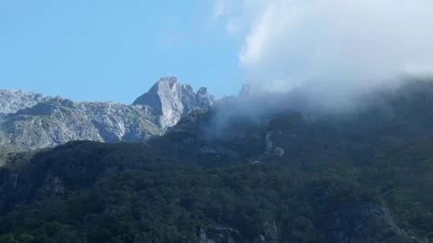 Looking up at mountain covered in clouds at Milford Sound Stock Footage 260367945