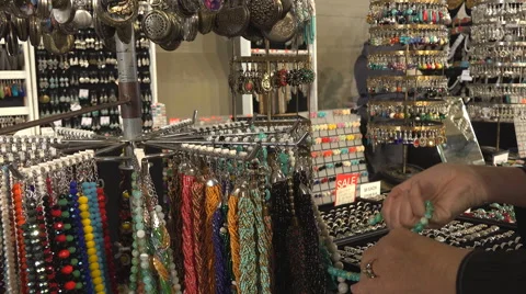 Looking at necklaces at market Stock Footage 52584427